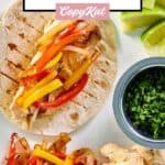 Grilled chicken fajitas, lime wedges, and fresh cilantro.