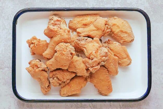 Breaded and fried chicken wings on a tray.