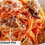 A bowl of spaghetti with chunks of Italian sausage.