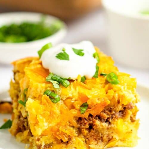 Mexican cornbread casserole topped with sour cream and fresh cilantro.