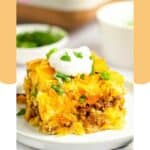 A serving of Mexican cornbread casserole topped with a dollop of sour cream.
