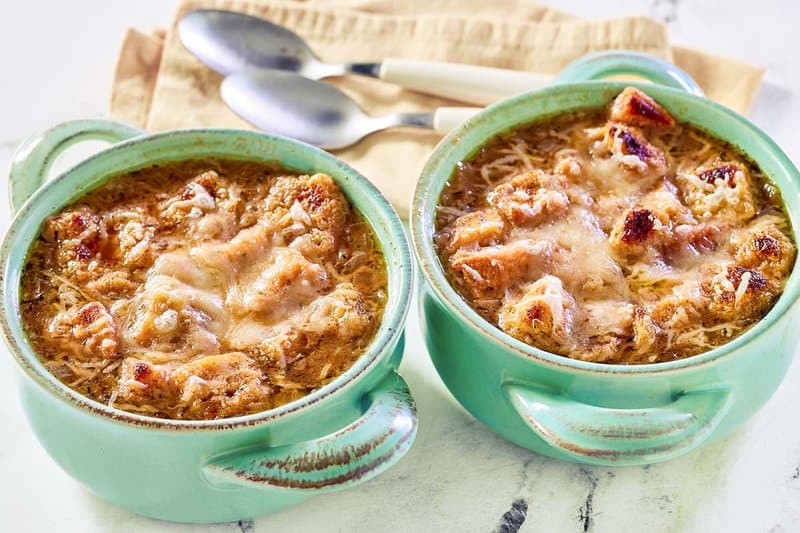 Copycat Panera Bread French onion soup in two bowls and two spoons on napkins.
