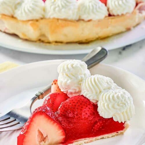 Copycat Shoney's strawberry pie slice on a plate and the pie behind it.