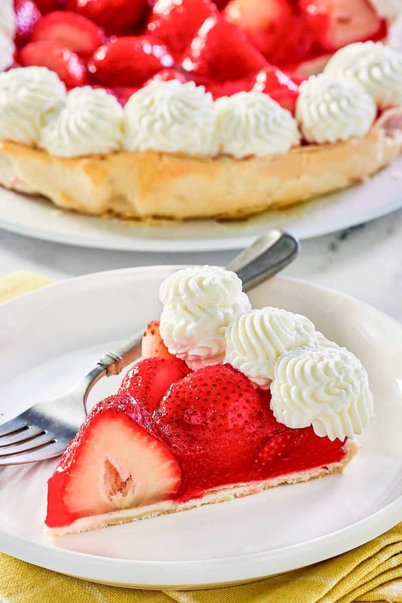 Copycat Shoney's strawberry pie slice on a plate and the pie behind it.