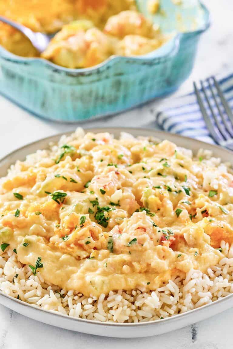 Shrimp and crab au gratin over rice on a plate.