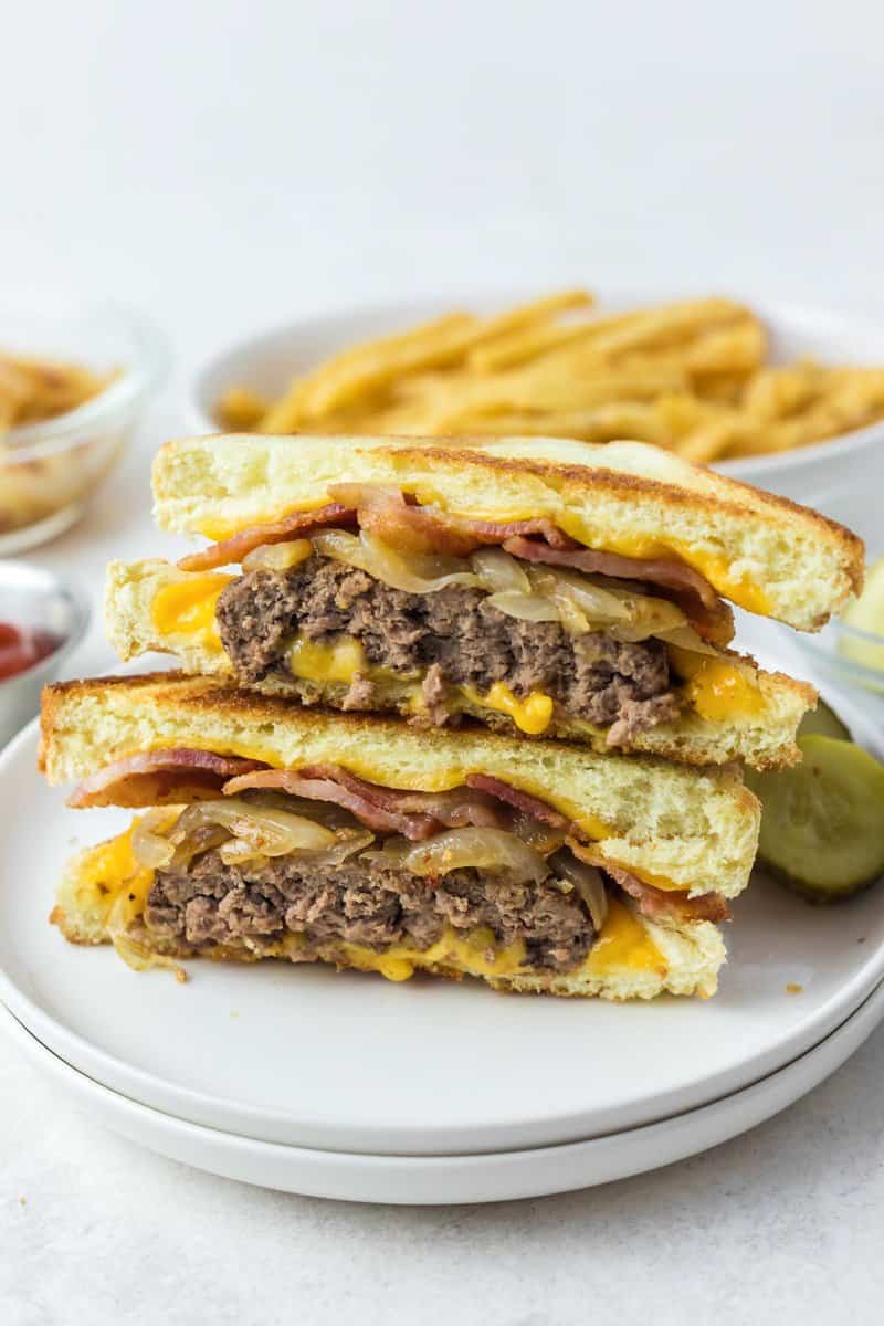 Copycat Waffle House Texas bacon patty melt sandwich halves stacked on a plate.