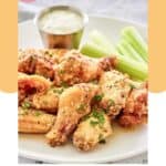 Homemade Wingstop garlic parmesan chicken wings, dipping sauce, and celery on a plate.