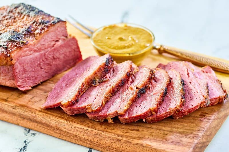 Baked corned beef on a wood board.