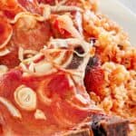 Baked pork chops and rice with onions and tomato sauce.