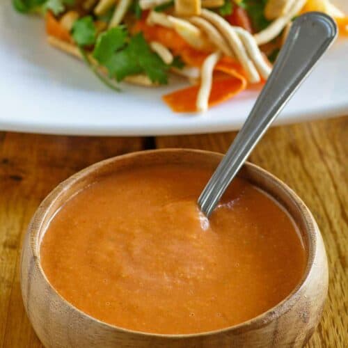 Copycat Benihana ginger salad dressing in a bowl and a salad behind it.