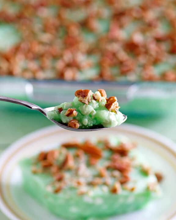 Copycat Furr's cafeteria lime jello salad on a spoon and plate and in a baking dish.