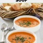 Copycat La Madeleine tomato basil soup in two bowls and a basket of bread.