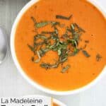 Homemade La Madeleine tomato basil soup garnished with chopped fresh basil.