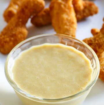 Copycat Outback Steakhouse honey mustard in a bowl and chicken fingers behind it.