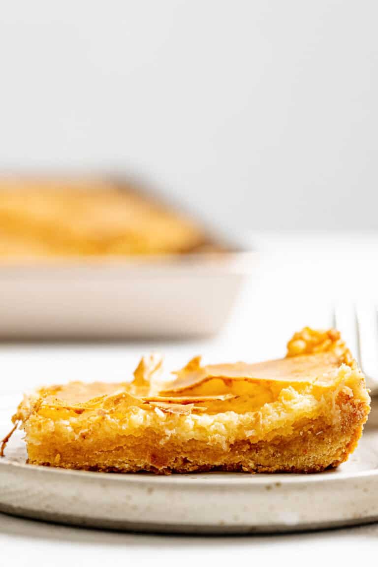 Copycat Treebeards butter cake slice on a plate with the cake behind it.