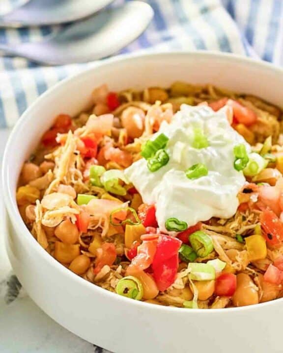 A bowl of crockpot white chicken chili with toppings.
