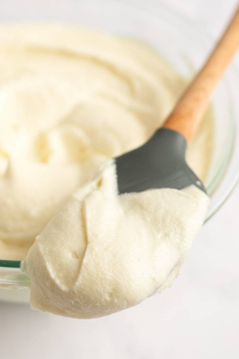 Copycat Cinnamon cream cheese frosting on a spatula and in a bowl.