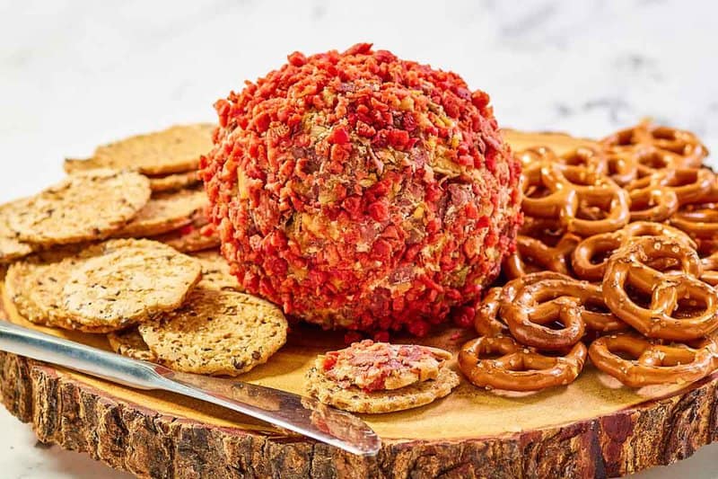 French onion cheese ball, pretzels, and crackers on a platter.