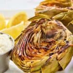 Grilled artichoke halves and a cup of garlic aioli.
