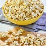 Instant pot popcorn scattered on parchment paper and in a bowl.