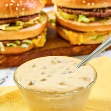 Copycat McDonald's big mac sauce in a small bowl and burgers behind it.