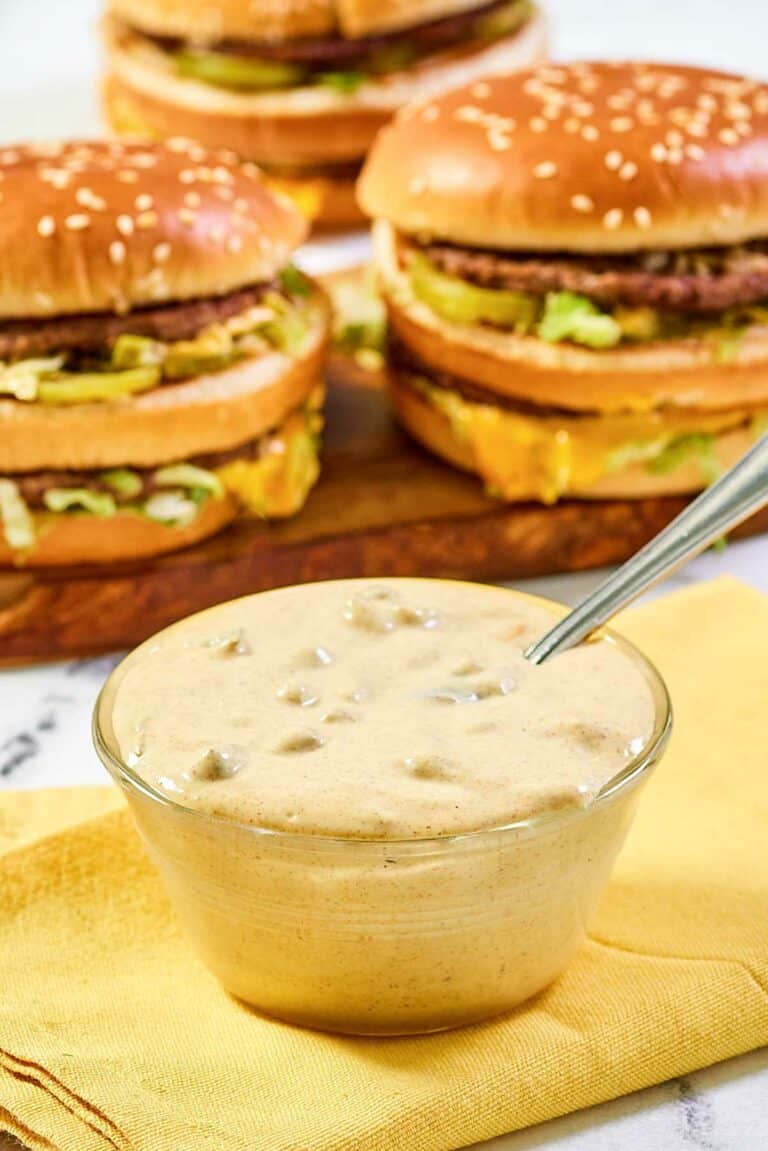 Copycat McDonald's big mac sauce in a small bowl and burgers behind it.