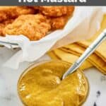 Homemade McDonald's hot mustard in a small bowl and a basket of chicken nuggets.