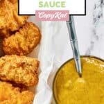 Homemade McDonald's hot mustard dipping sauce next to a basket of chicken nuggets.