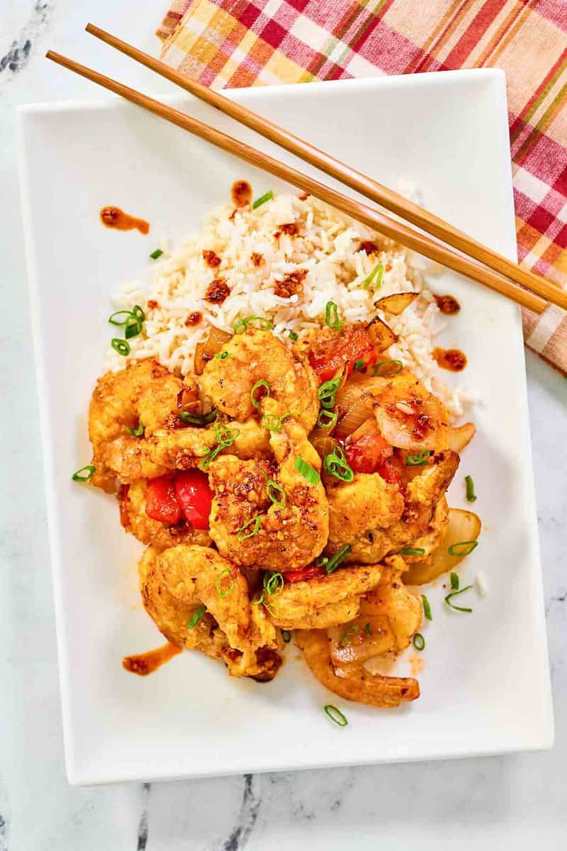 Copycat Panda Express chili crisp shrimp and rice on a plate.