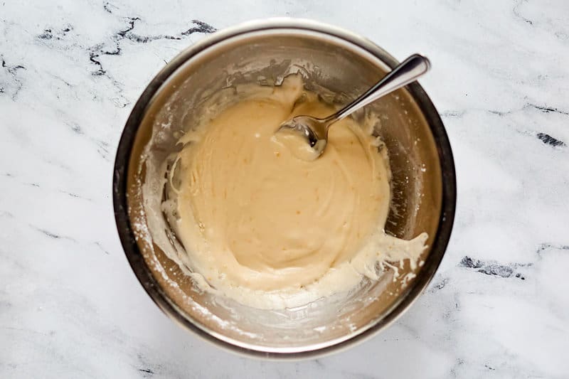 Vanilla icing for copycat Panera cinnamon rolls in a bowl.