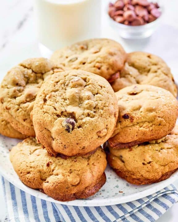 Copycat Panera kitchen sink cookies on a plate and a glass of milk behind it.