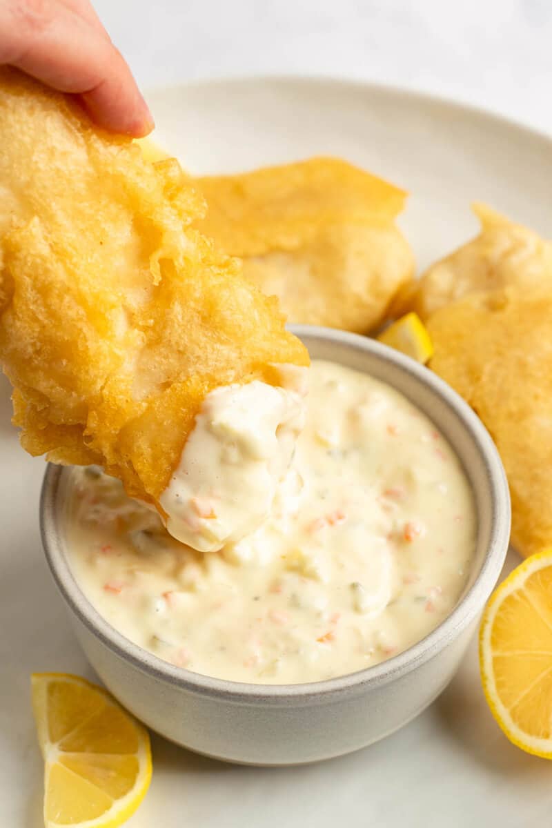 Dipping fried fish into a bowl of copycat Red Lobster tartar sauce.
