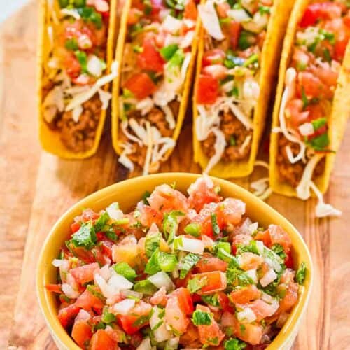 A bowl of copycat Applebee's pico de gallo and four tacos.