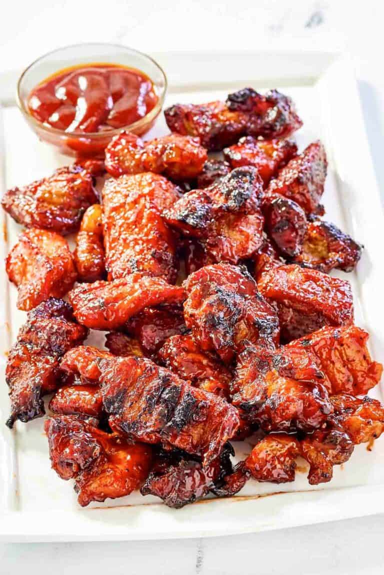 Copycat Applebee's riblets and a small cup of barbecue sauce on a platter.