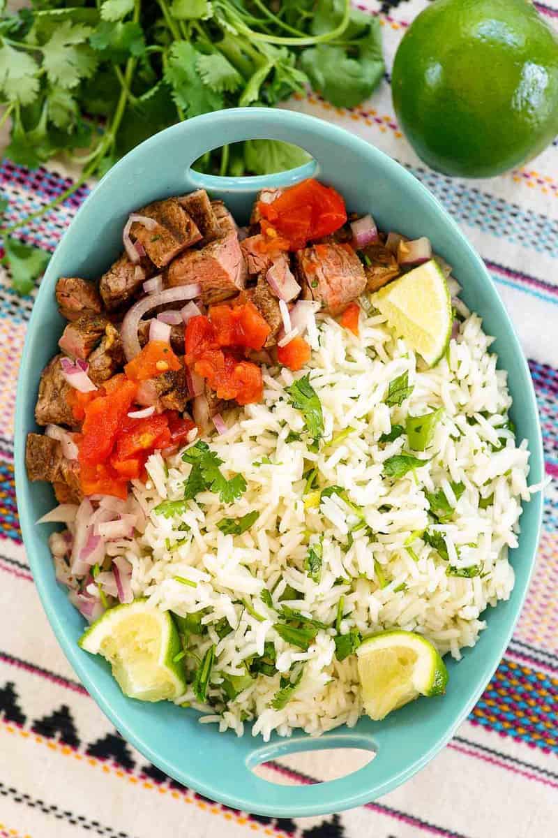 Copycat Chipotle cilantro lime rice and steak bites in a bowl.