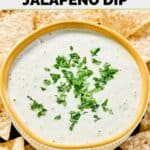 Homemade Chuy's creamy jalapeno dip in a bowl and tortilla chips around it.