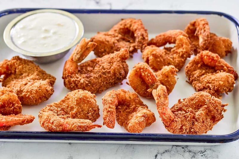 Copycat Red Lobster coconut shrimp and a small cup of dipping sauce.