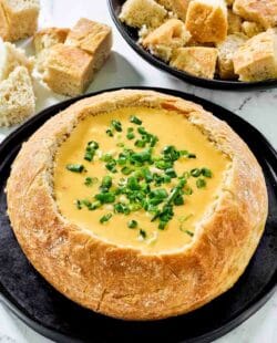 Copycat Red Lobster ultimate fondue in a bread bowl and bread cubes beside it.