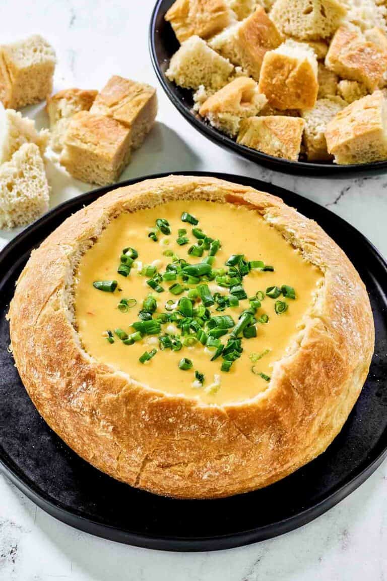 Copycat Red Lobster ultimate fondue in a bread bowl and bread cubes beside it.