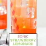 A glass of homemade Sonic strawberry lemonade and a strawberry.