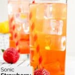 Two glasses of homemade Sonic strawberry lemonade and two strawberries.