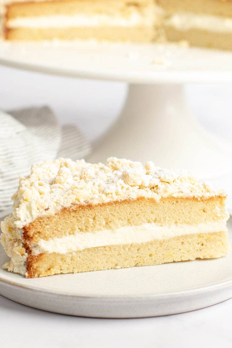 Copycat Olive Garden lemon cream cake slice on a plate in front of the cake.