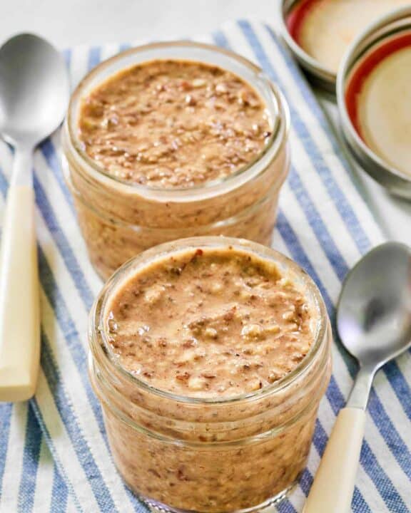 Homemade brekki overnight oats in jars and two spoons.