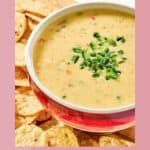 A bowl of copycat Chipotle queso blanco and tortilla chips beside it.