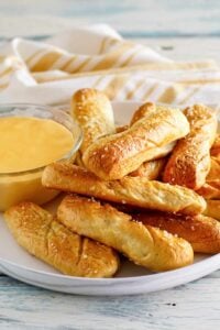 Copycat TGI Friday's soft pretzel sticks and beer cheese dip on a plate.