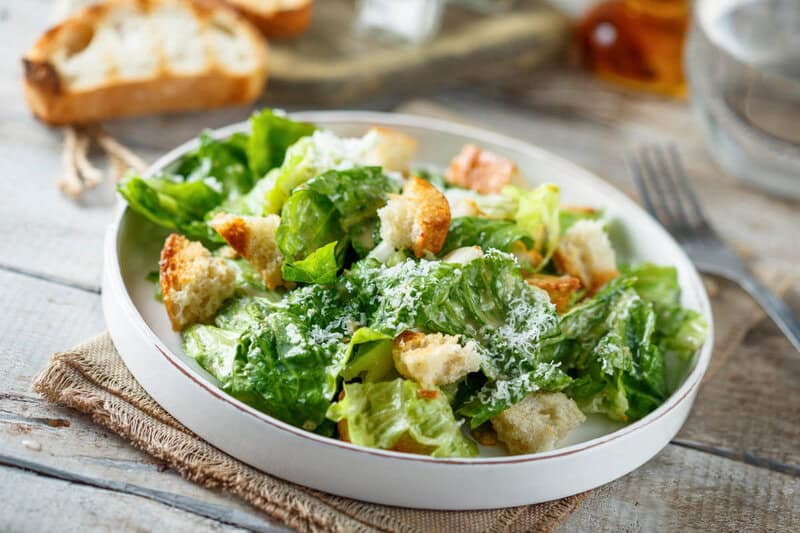 Copycat Anthony's Caesar salad on a plate on top of a cloth napkin.