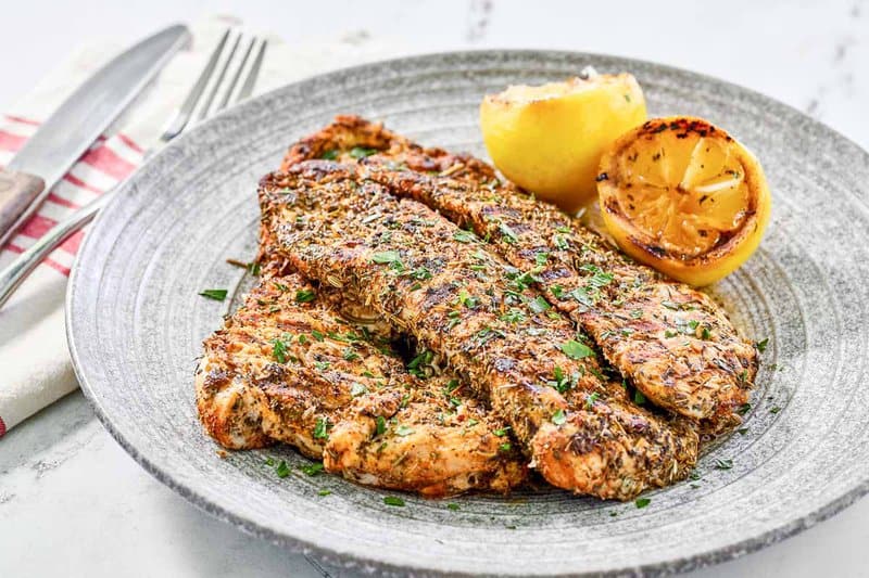 Copycat Texas Roadhouse herb crusted chickenhearted  breasts connected  a plate.