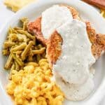 Copycat Cracker Barrel country fried pork chops with gravy, green beans, and mac and cheese.