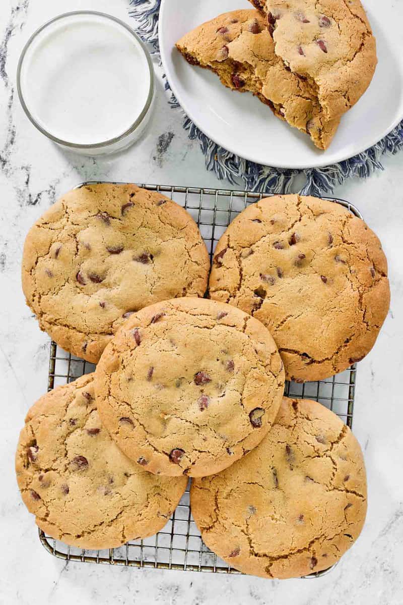 Copycat Crumbl chocolate chip cookies on a plate and wire rack.