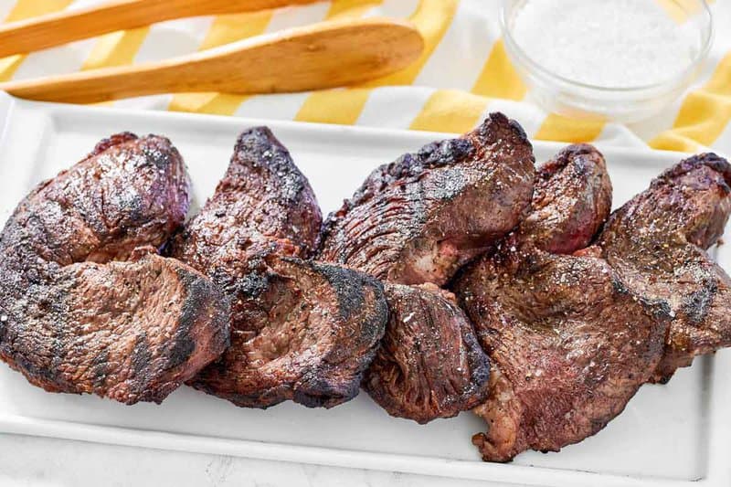 Several copycat Fogo de chao picanha steaks on a platter.